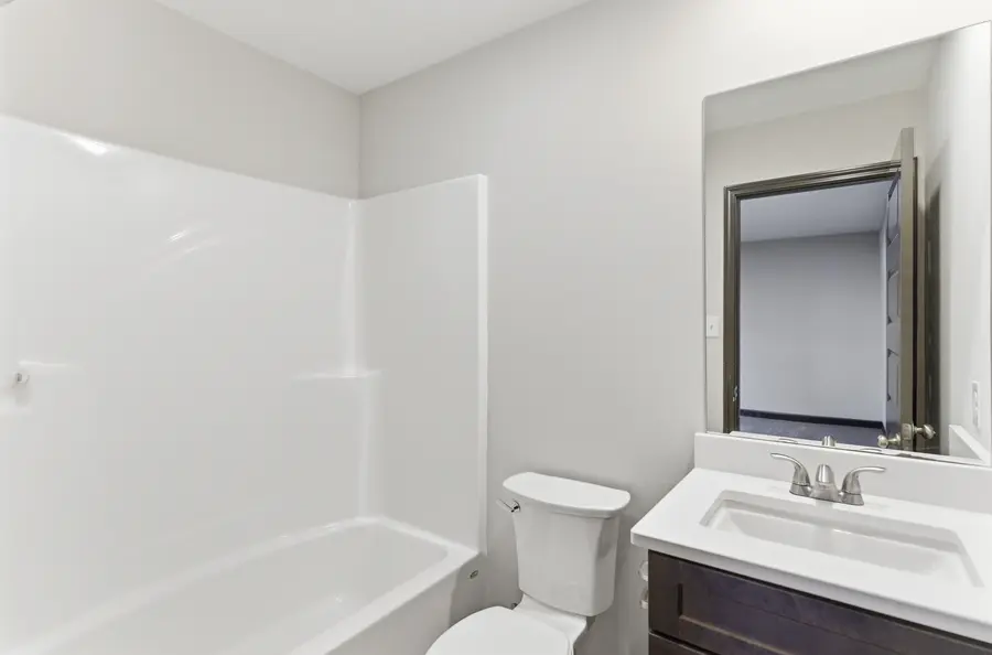Bathroom with a dark vanity and tub shower
