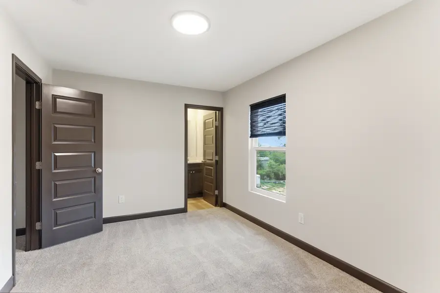 Carpeted townhome bedroom with a window and ensuite door