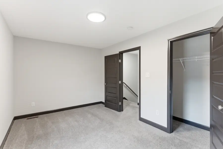 Carpeted bedroom with a walk-in closet
