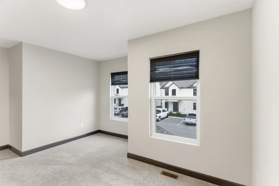 Carpeted bedroom with a window over the parking