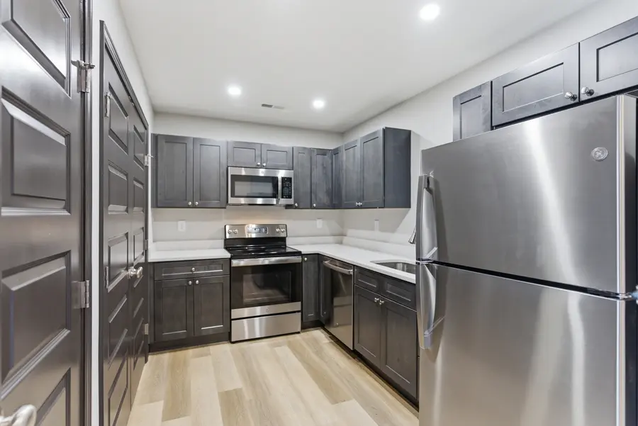 Kitchen with dark shaker cabinets and a stainless refrigerator