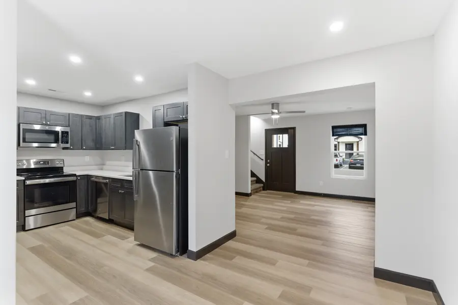 Townhome kitchen with dark cabinets and stainless appliances, open to the living area