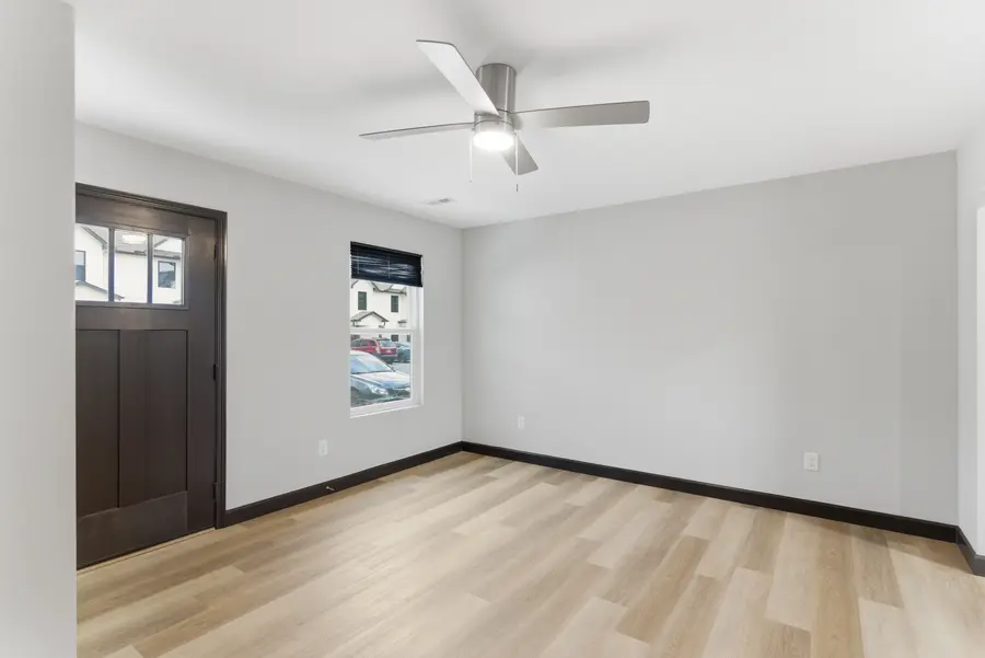 Townhome living room with a ceiling fan and light plank floors