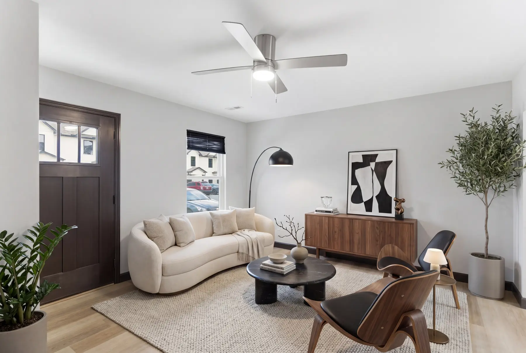 Staged townhome living room with a curved sofa and light plank floors