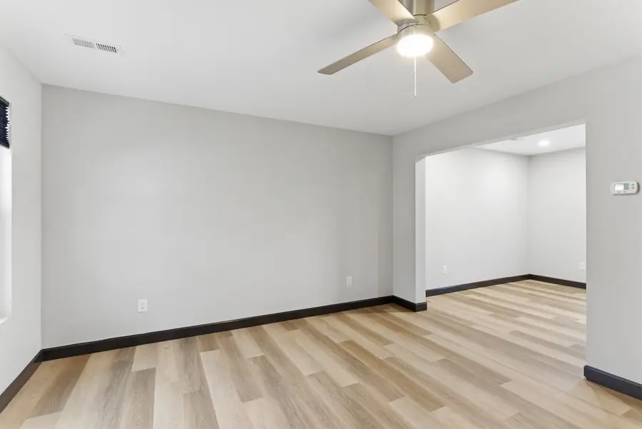 Empty townhome living room with a ceiling fan