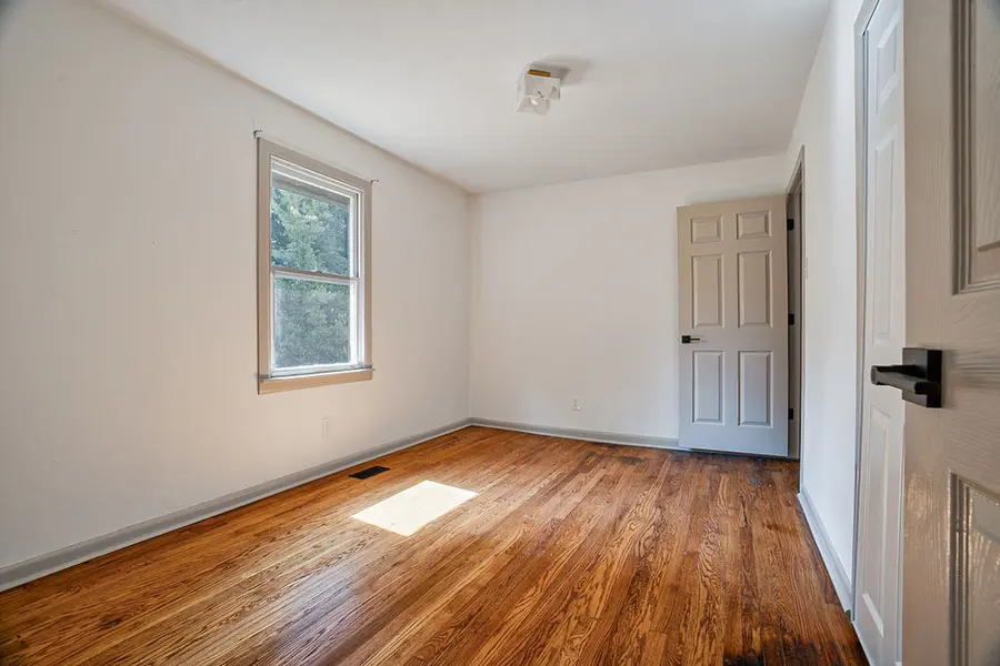Bedroom with hardwood floors and a window