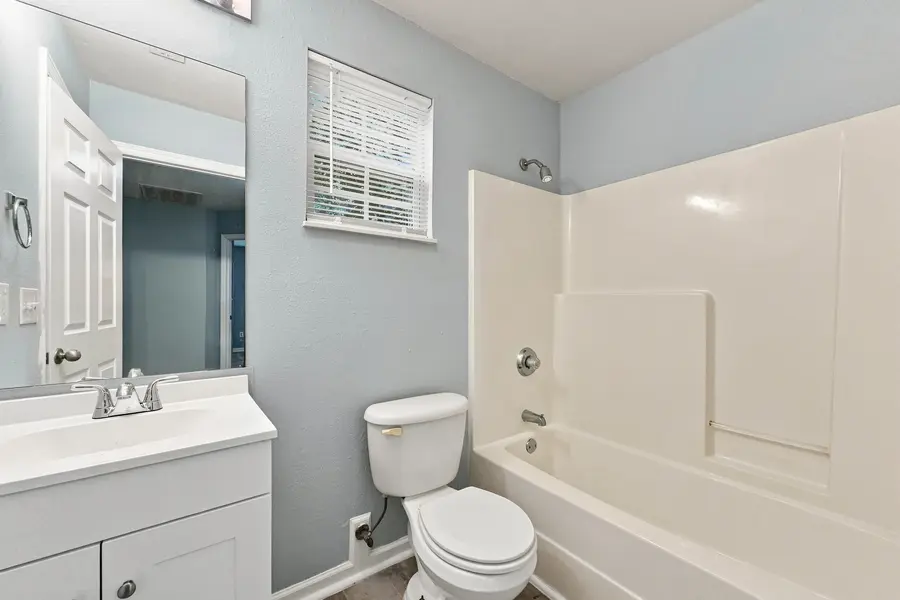 Bathroom with a tub shower and white vanity