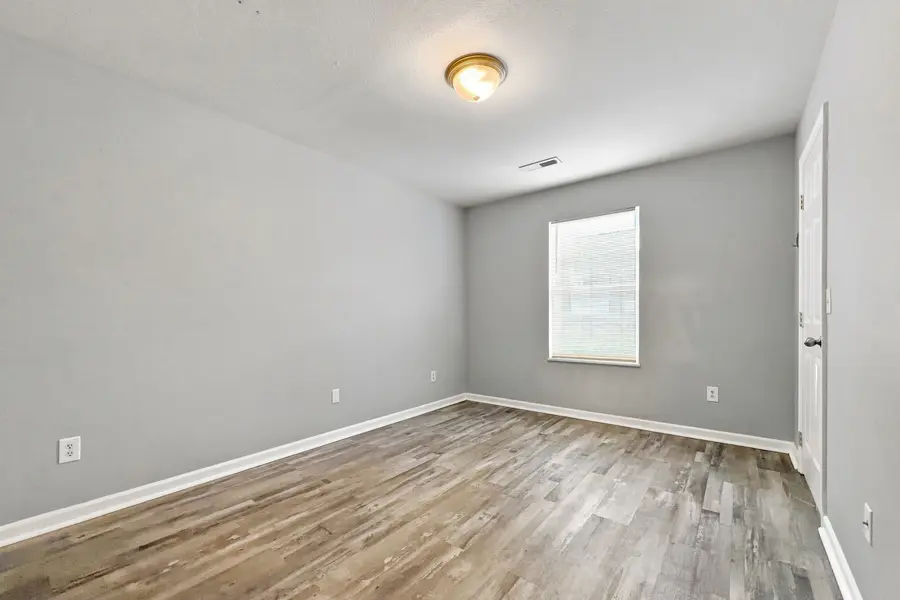 Bedroom with plank floors and a window