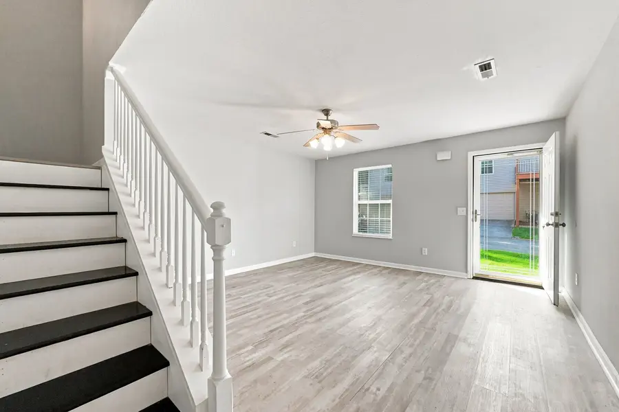 Townhome living room with the staircase and a door to the deck