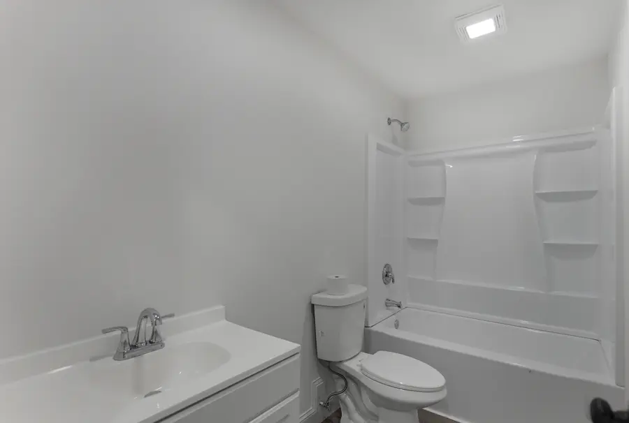 Bathroom with a tub shower and white vanity