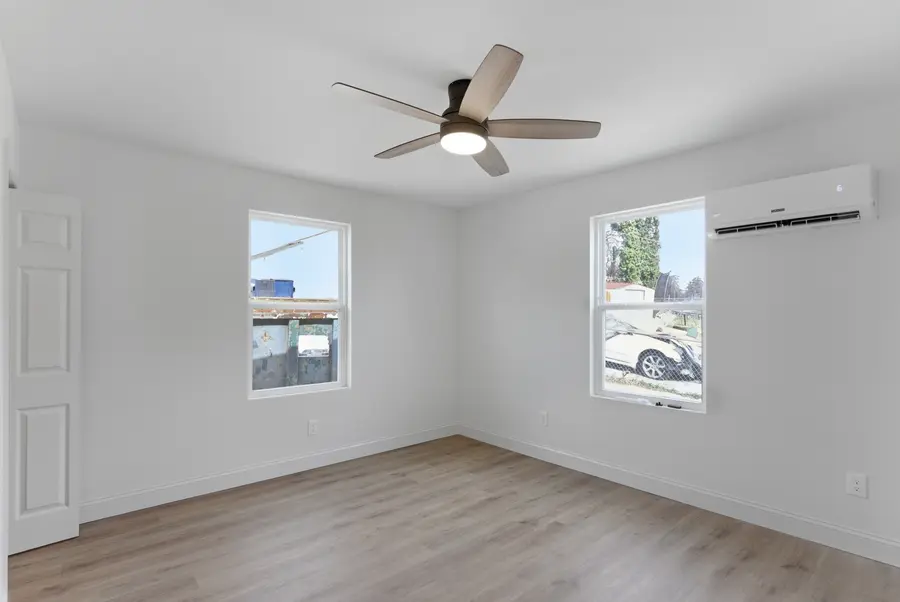 Bedroom with a ceiling fan and two windows
