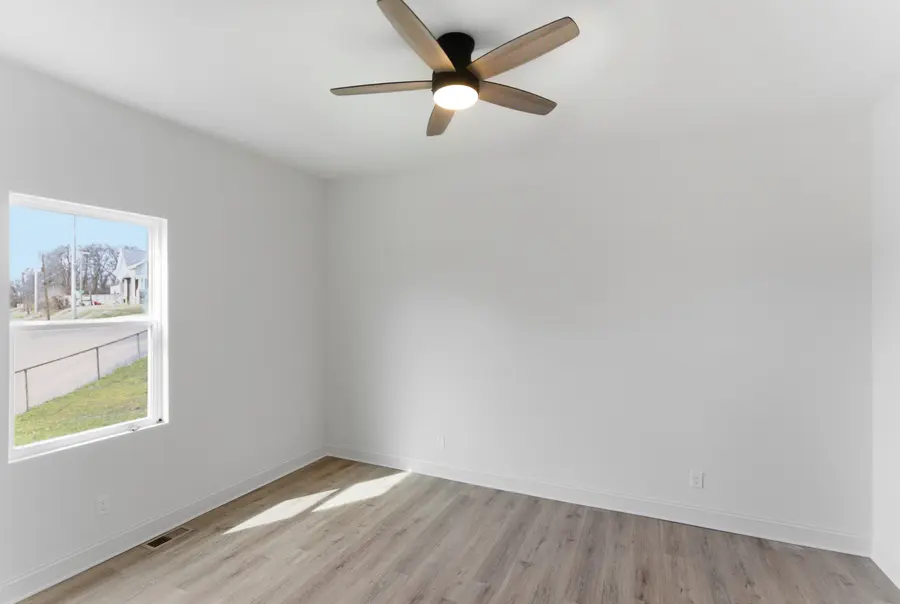 Bedroom with a ceiling fan and plank floors