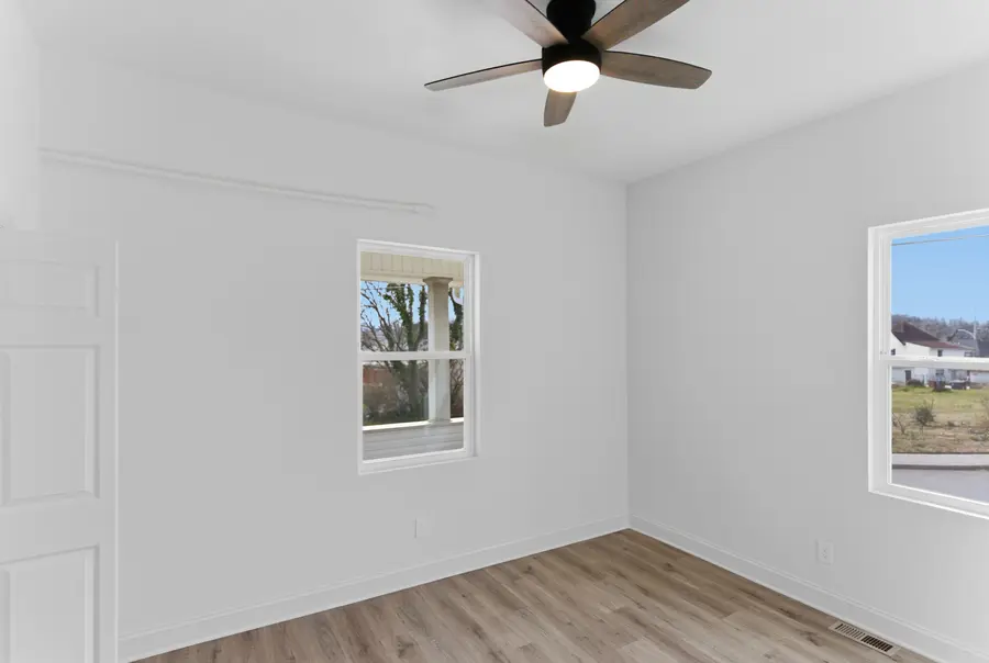 Bedroom with a ceiling fan and two windows