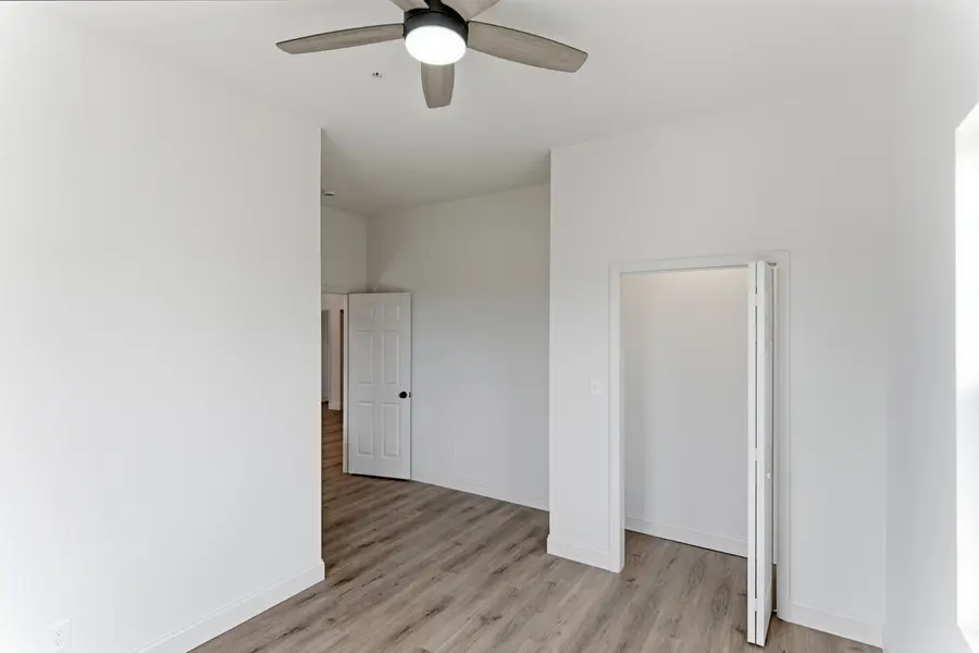 Room with a ceiling fan and open doorway