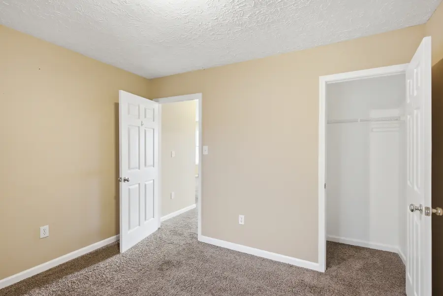 Carpeted bedroom with a closet and hall door