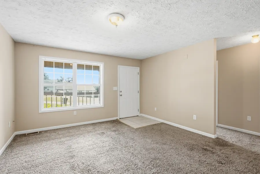 Carpeted living room with a front window