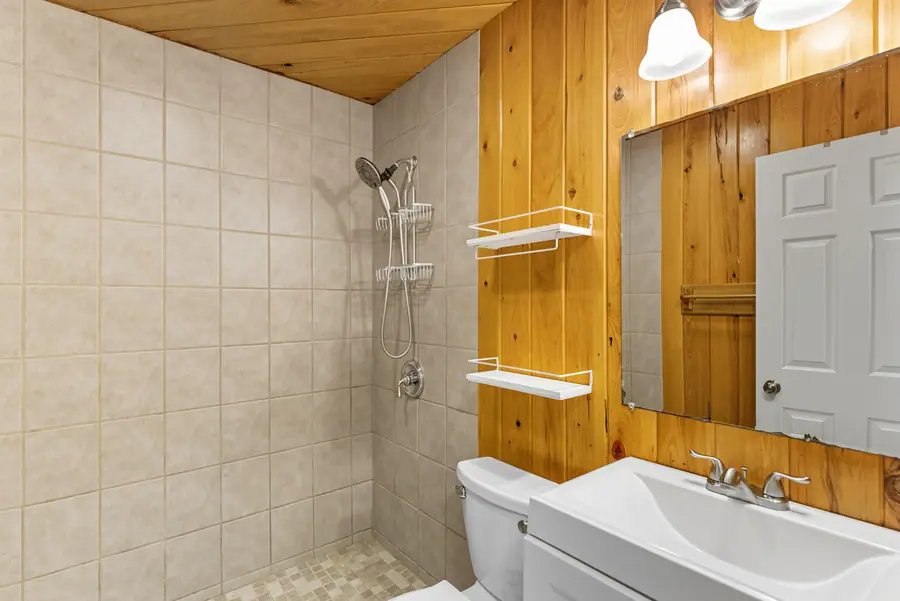 Bathroom with a tiled shower and cedar panelling