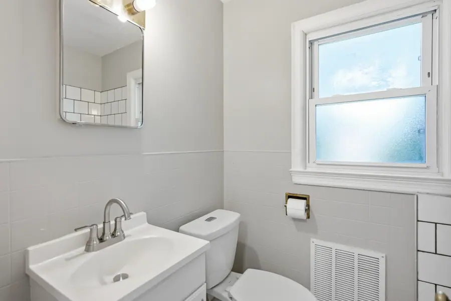 Bathroom with a tiled surround and a frosted window