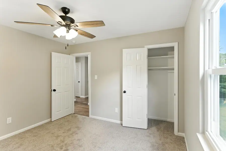 Carpeted bedroom with a double closet