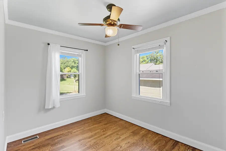 Bedroom with a ceiling fan and two windows
