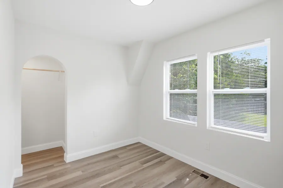 Room with an arched alcove and luxury vinyl plank flooring