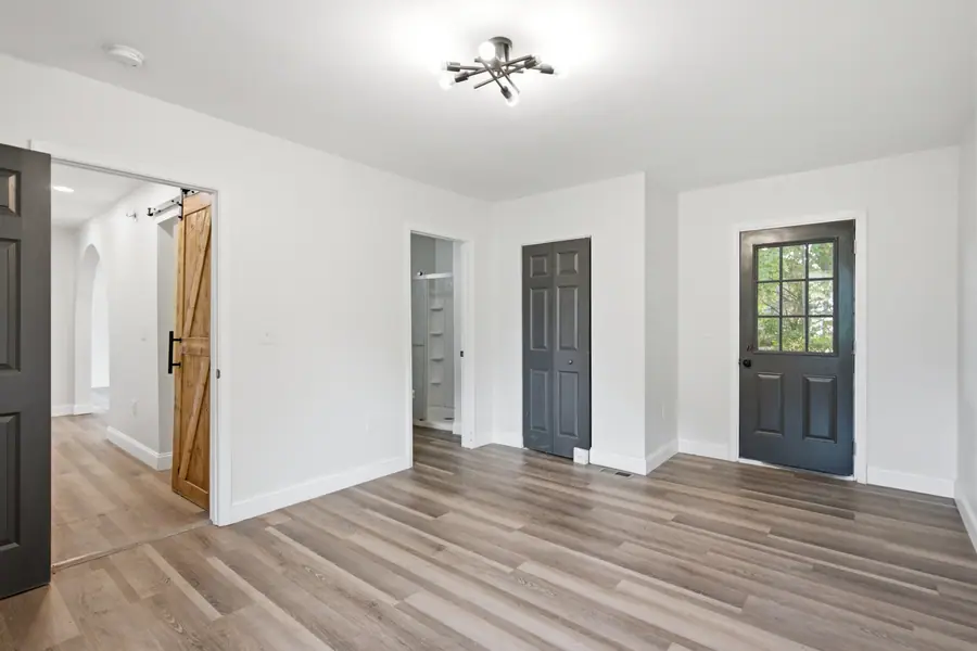 Open living area with a sliding barn door and refinished floors