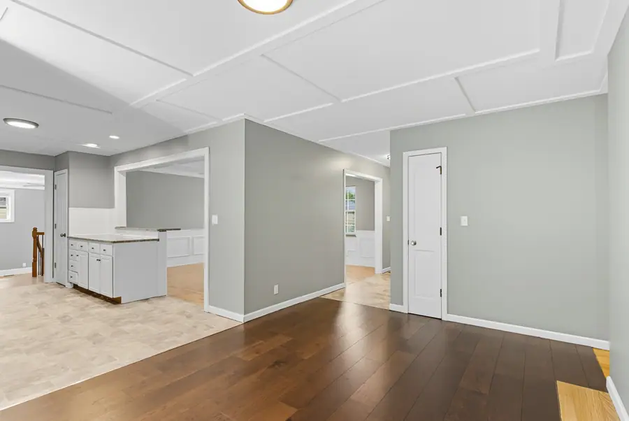 Open living space with a panelled ceiling and hardwood floors
