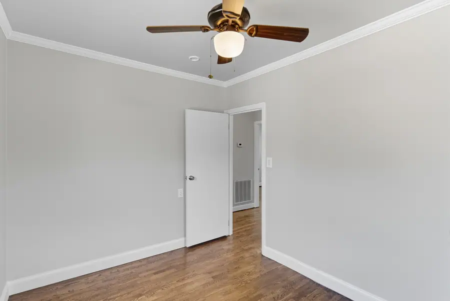 Room with a ceiling fan opening to the hall