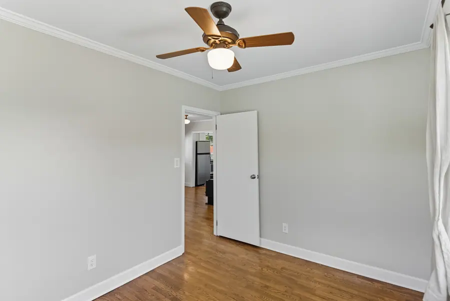 Room with a ceiling fan and refinished hardwood floors