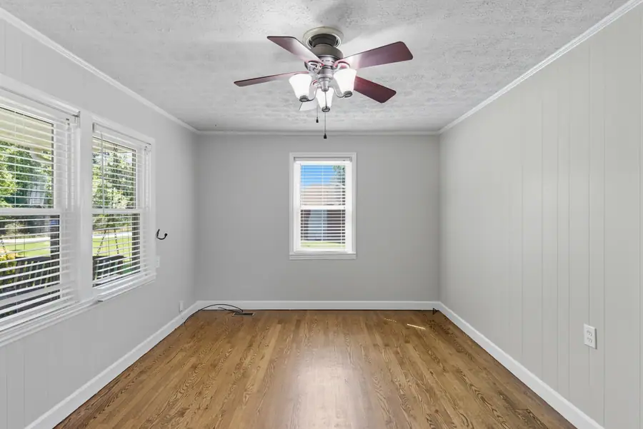 Room with panelled walls and windows on two sides