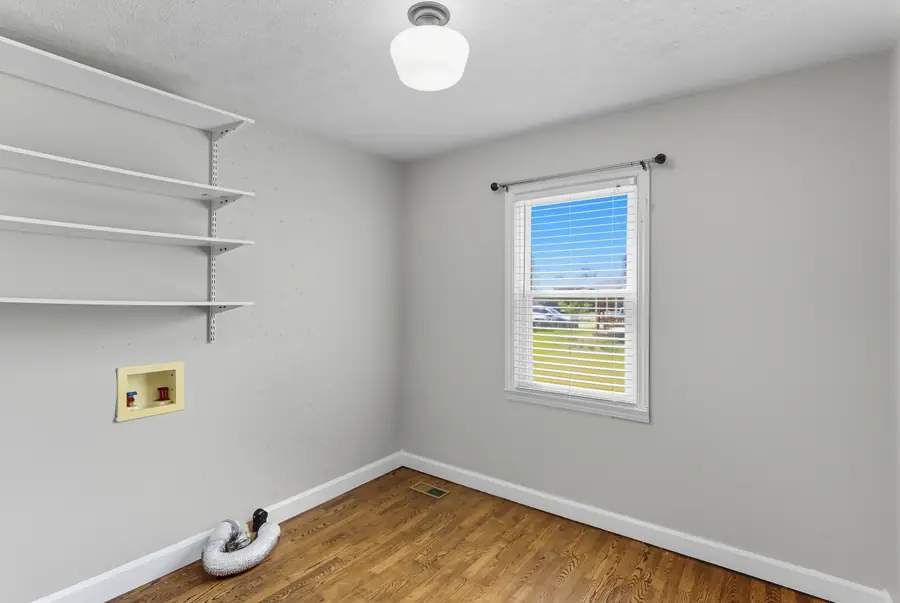 Room with fitted wall shelves and hardwood floors