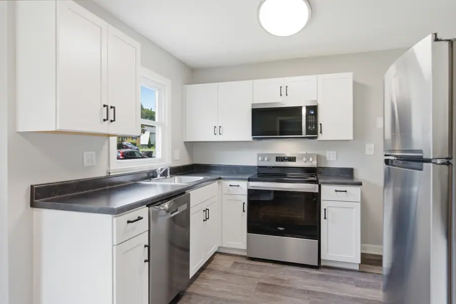 Kitchen with dark counters and white cabinetry