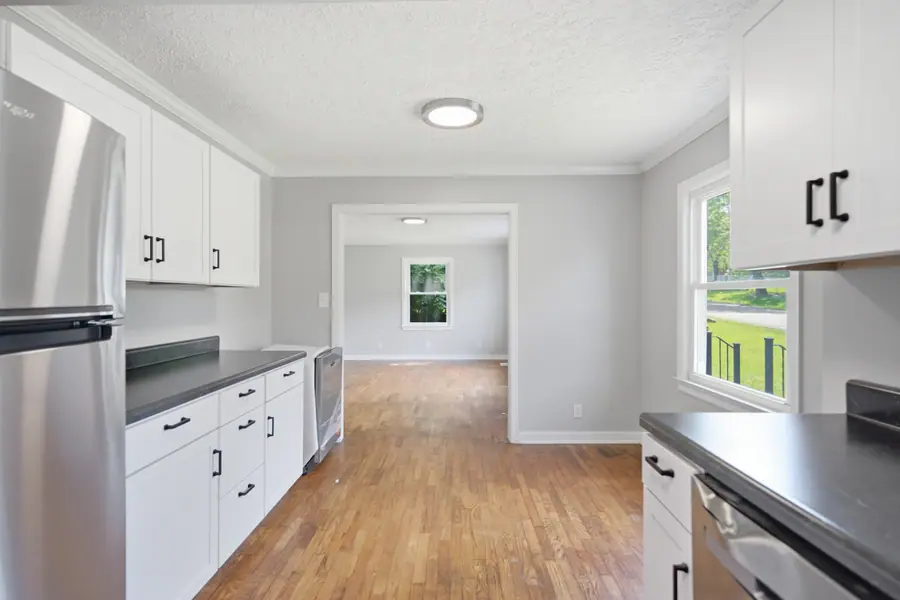 Kitchen with a stainless refrigerator open to the living area
