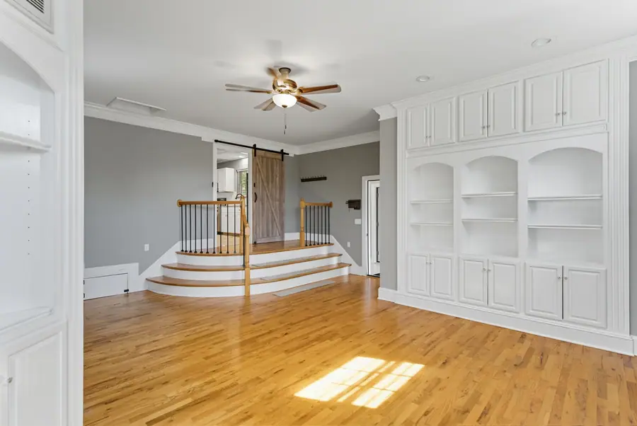 Living room with built-in shelving beside the staircase
