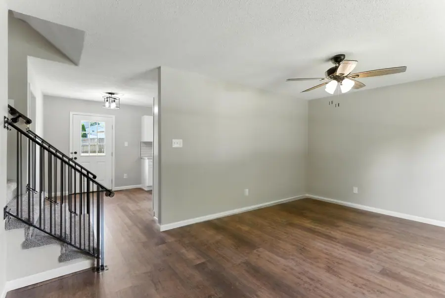 Living area beside the staircase with a ceiling fan