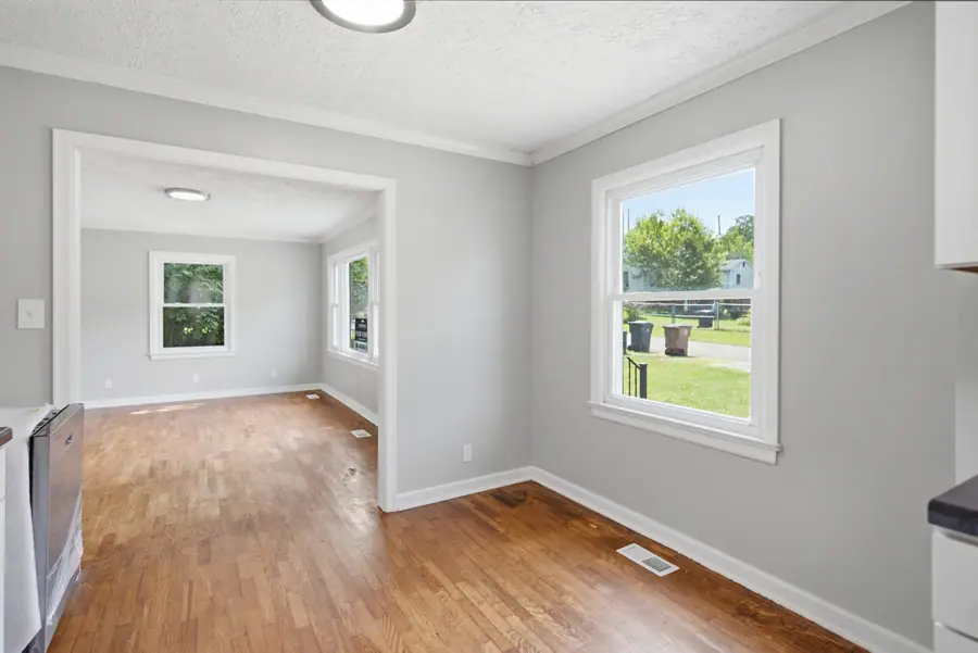 Living room with hardwood floors and windows to the yard
