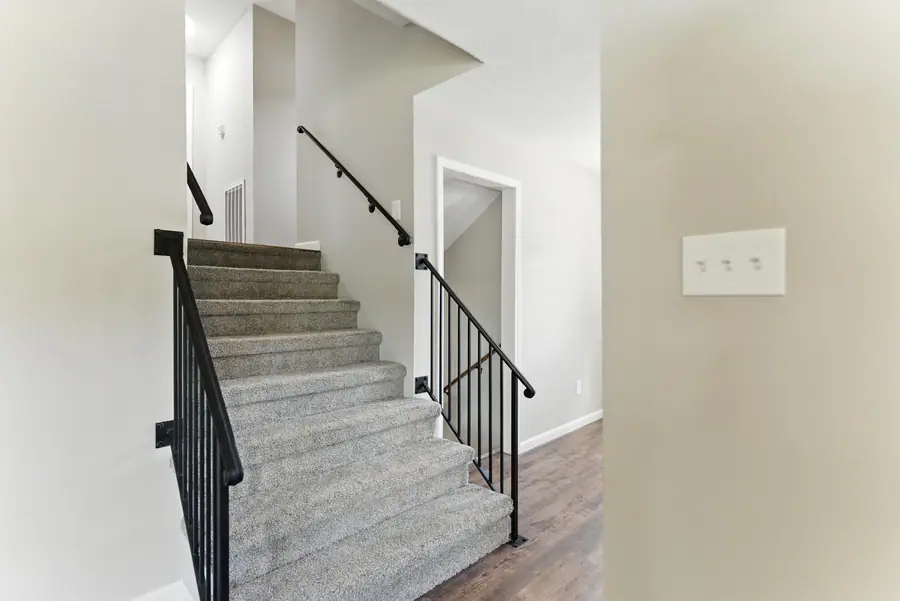 Carpeted staircase with iron balusters